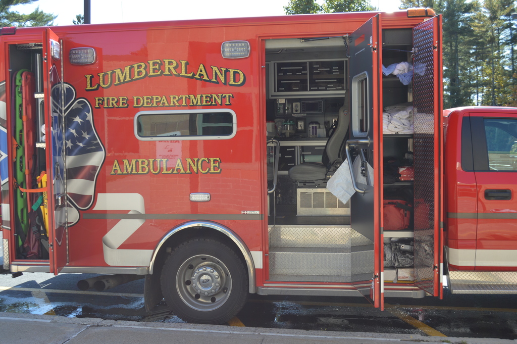 A red Lumberland Fire Department Ambulance is parked with it's doors open showing the equipment inside