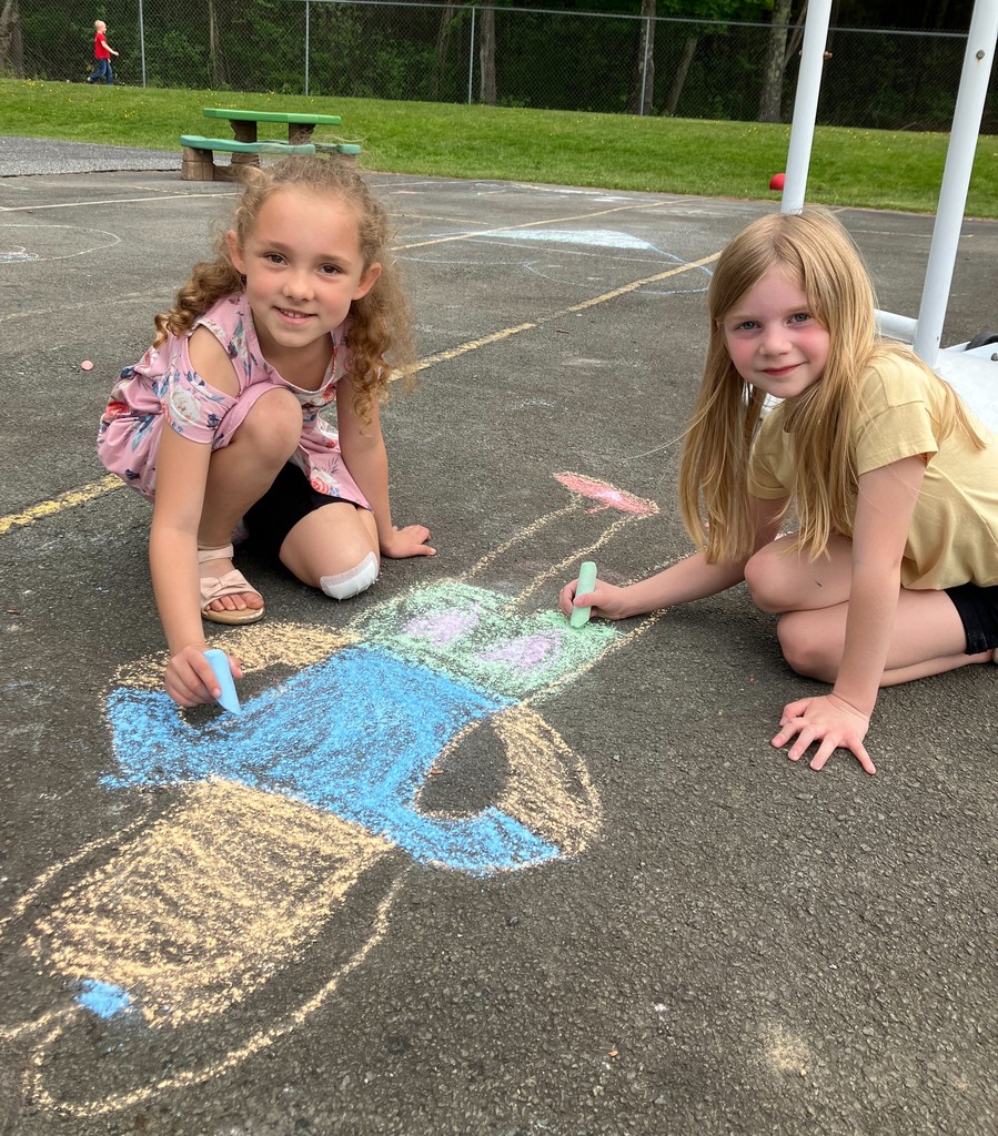 Image of two students drawing with chalk at playground club