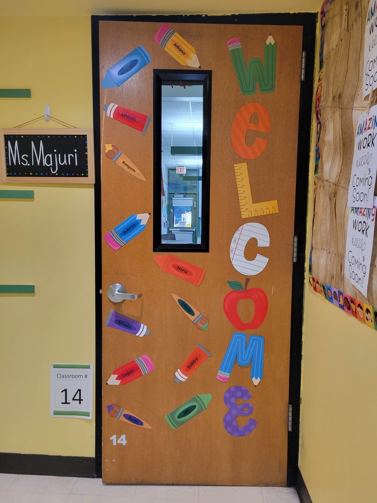 Wooden door with a window in it that has a welcome sign with pencil and crayons cutouts