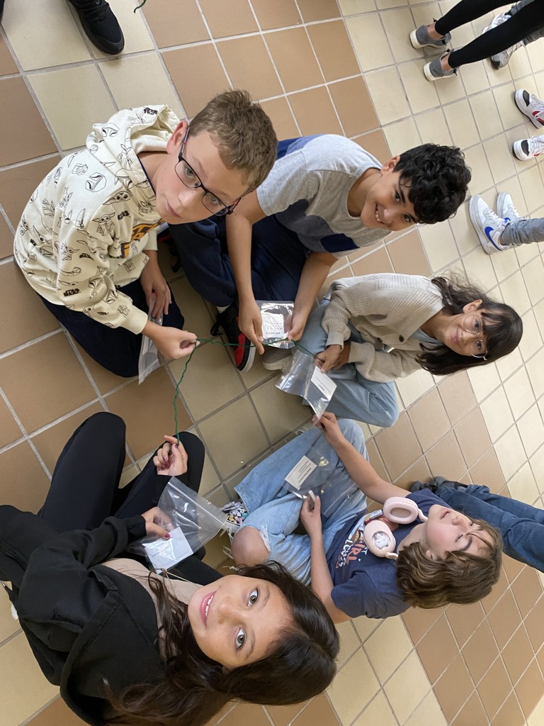 Students holding string working on a science lab