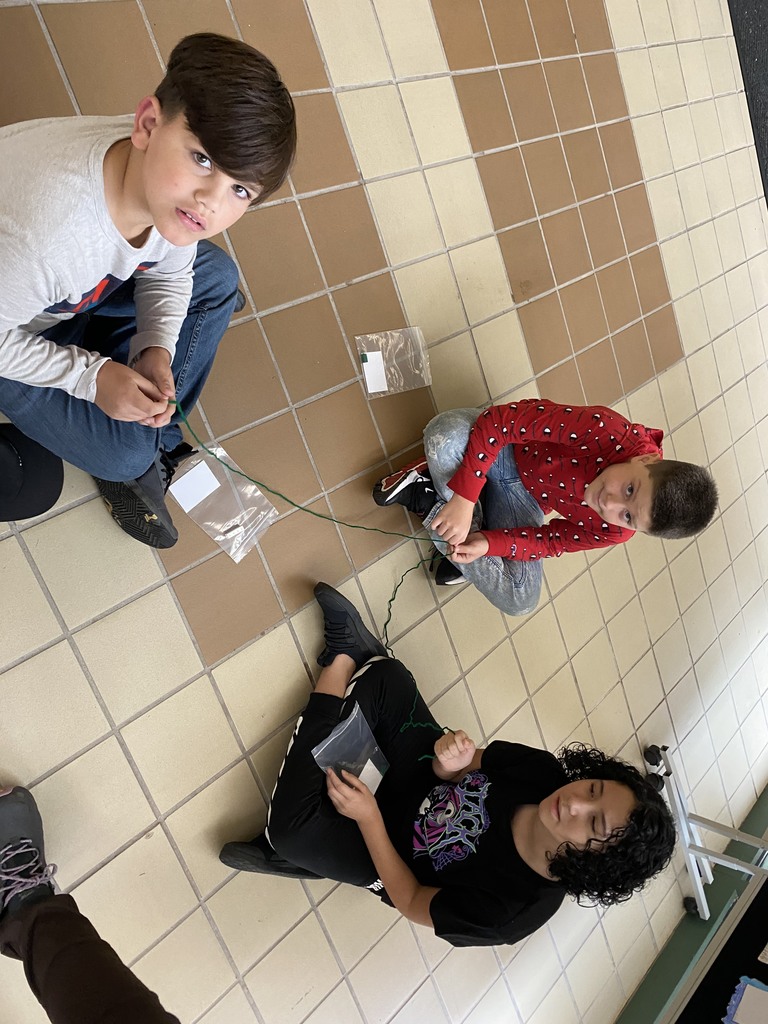 Students holding string working on a science lab