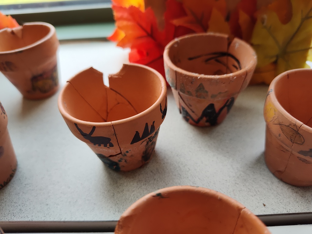 Image of terra cotta pots with images drawn on them