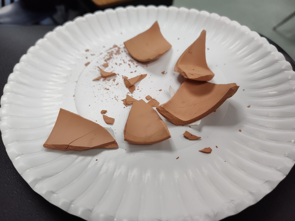 image of broken pieces of terra cotta pots on a white plate